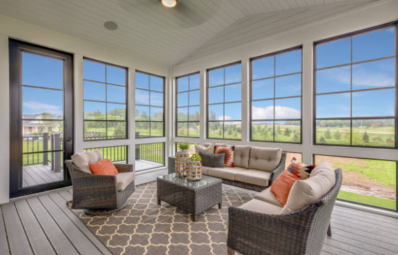Glassed-in sunroom with wicker furniture and scenic outdoor view